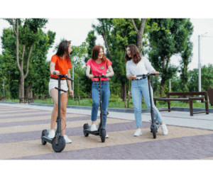 Three girls riding an e-scooter