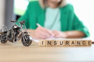 motorcycle-insurance-illustrated-by-a-small-motorcycle-and-the-word-insurance-spelled-out-with-blocks