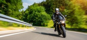A man rides a motorcycle down the road. When do most motorcycle accidents occur