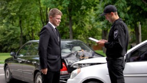 A man talks with a police officer at the scene of a Florida car accident. A personal injury lawyer can advise you on how to get a copy of the police report, or they can get one for you.