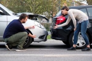A male and female motorist argue after a rear-end collision, as one explains to the other how brake checking is illegal in Florida.